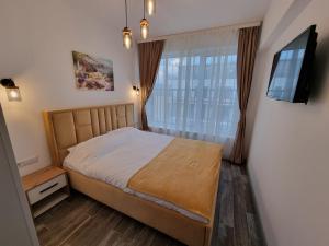 Habitación pequeña con cama y ventana en My Marble Apartment, en Sibiu