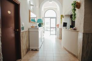 a hallway with a kitchen with an arched doorway at Hotel Torino in Brindisi
