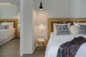 a bedroom with a large bed with blue and white pillows at Anassa Suites Stalis by Estia "Adults Only" in Stalida