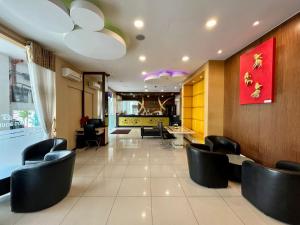 a waiting room with black chairs and a table at Eight Days Boutique Hotel - Impian Emas in Skudai