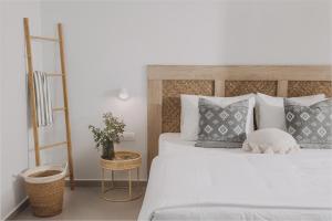 um quarto com uma grande cama branca com almofadas em Anassa Suites Stalis by Estia "Adults Only" em Stalida