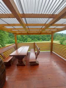 porche de madera con mesa de picnic y bancos en Lahinja & Kolpa river apartments, en Metlika
