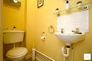 a bathroom with a toilet and a sink at Camberley Spacious and Comfy 3 Bedroom Home, Next to Frimley Hospital with Parking in Frimley