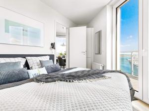 a bedroom with a large bed and a large window at Moderne Ferienwohnung direkt am Meer in Wendtorf