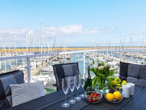 a table with wine glasses and a view of a marina at Moderne Ferienwohnung direkt am Meer in Wendtorf