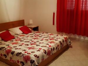 a bed in a bedroom with a red curtain at Apartments Cumbelic in Kozarica