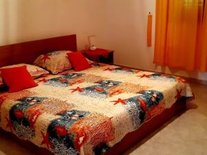 a bed with a quilt with stars on it at Apartments Cumbelic in Kozarica