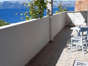 balcón con mesa, sillas y vistas al agua en Apartments Cumbelic, en Kozarica