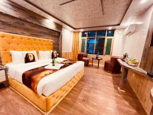 a bedroom with a large bed with a woman laying on it at Hill River Resort - Central Heated & Air cooled in Manāli