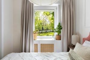 Schlafzimmer mit einem Fenster mit einem Bett und einem Spiegel in der Unterkunft Elite Apartments Beachfront in Danzig