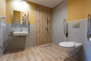 y baño con aseo, lavabo y ducha. en Apartamenty Albatros, en Augustów