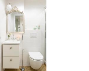 ein Badezimmer mit einem WC, einem Waschbecken und einem Spiegel in der Unterkunft Elite Apartments Beachfront in Danzig