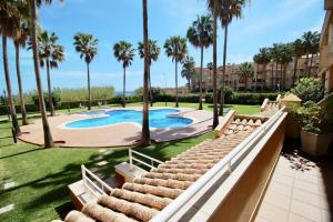 um resort com piscina e palmeiras em El Amanecer 93 em Denia