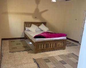 a bedroom with a bed with a wooden frame at Al Kahina Gardens, Retreat and Resort in Siwa