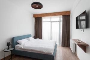 1 dormitorio con cama y ventana en Gudauri Ski Resort - Alpic Mountain View Apartments, en Gudauri