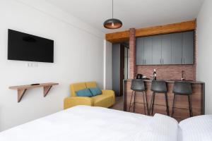 1 dormitorio con 1 cama y un bar con taburetes en Gudauri Ski Resort - Alpic Mountain View Apartments, en Gudauri