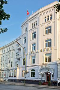 ein weißes Gebäude mit einer Flagge darüber in der Unterkunft Relexa Hotel Bellevue an der Alster in Hamburg