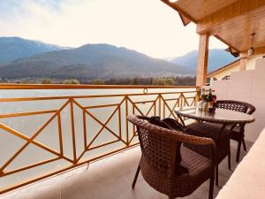 a patio with a table and chairs on a balcony at Hill River Resort - Central Heated & Air cooled in Manāli
