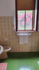 uma casa de banho com um WC e uma janela em 4 stagioni em Villasimius