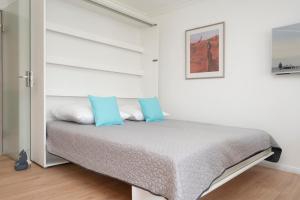 - une chambre avec un lit et des oreillers bleus dans l'établissement Miramar Wohnung 510, à Grömitz