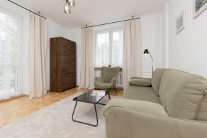 ein Wohnzimmer mit einem Sofa und einem Tisch in der Unterkunft Bałuckiego Apartment Stary Mokotów Warsaw by Renters in Warschau