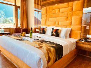 a bedroom with a large bed with a wooden headboard at Hill River Resort - Central Heated & Air cooled in Manāli