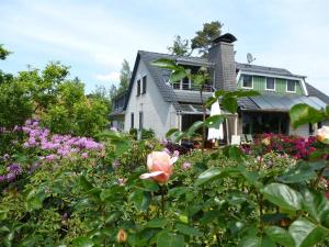 a house with a garden of flowers in front of it at Haus 52° Nord, Ferienwohnung in Winsen Aller