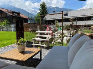 a patio with a bench and a table and a chair at s'batlogg8 in Schruns