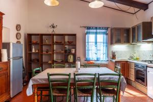 a kitchen with a table with chairs and a refrigerator at Podere Par di Rota in Calci
