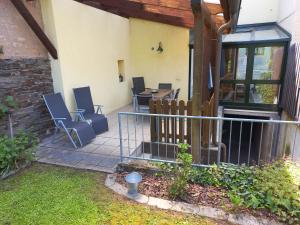 a patio with chairs and a table and a fence at Ferien im Winzerhaus in Traben-Trarbach
