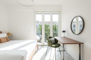 1 dormitorio con cama, escritorio y espejo en numa I Verso Apartments, en Roma