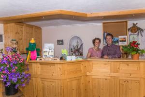 a man and woman standing at a counter in a salon at Appartements Wiesbach in Ramsau am Dachstein
