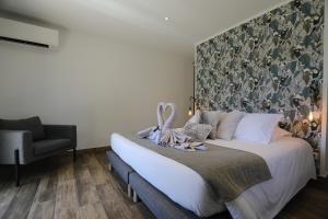 a bedroom with a bed with a large headboard at Hôtel confidentiel Le Grecale in Pianottoli-Caldarello
