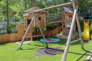 einen Spielplatz mit Holzhaus und Schaukel in der Unterkunft Appartement Désirée inkl der SUPER SOMMER CARD im SOMMER 2025 in Serfaus