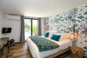 een slaapkamer met een groot bed met bloemenbehang bij Hôtel confidentiel Le Grecale in Pianottoli-Caldarello