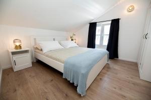 een witte slaapkamer met een bed en een raam bij The Jazz Makarska Apartment, Old town located in Makarska