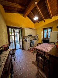 a kitchen with a table and a dining room at Old Village Linda - Tra Lunigiana & Cinque Terre in Comano