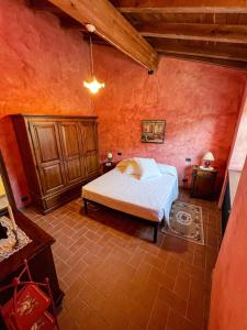 ein Schlafzimmer mit einem Bett in einem roten Zimmer in der Unterkunft Old Village Linda - Tra Lunigiana & Cinque Terre in Comano
