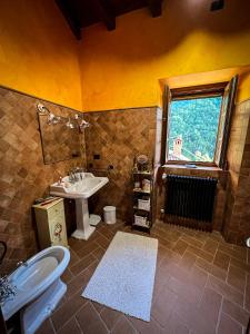 a bathroom with a sink and a toilet and a window at Old Village Linda - Tra Lunigiana & Cinque Terre in Comano