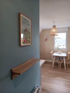 une salle à manger avec une table et une photo sur le mur dans l'établissement Appartement Détente au Cœur du Cotentin, à Valognes