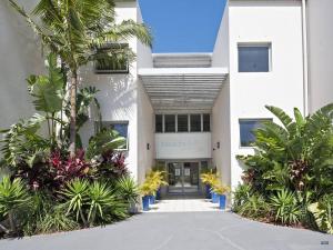 a white building with plants in front of it at MikaLex - Walking distance from the beach! in Nelson Bay