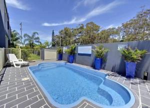 a swimming pool in a backyard with a fence and plants at MikaLex - Walking distance from the beach! in Nelson Bay