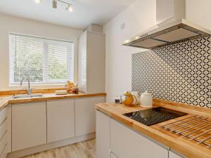 a kitchen with white cabinets and a counter top at Claro Mews Gem in Knaresborough