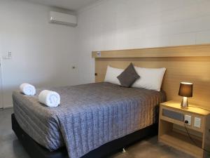 ein Schlafzimmer mit einem Bett mit zwei Handtüchern darauf in der Unterkunft Y Motels Rockhampton in Rockhampton