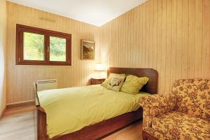 1 dormitorio con 1 cama, 1 silla y 1 ventana en Le Schwarzwald - A proximité des stations de ski, en La Bresse