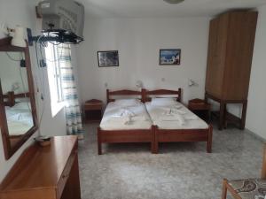 a bedroom with a bed in a room with a mirror at Roses Studios in Karpathos
