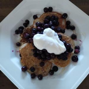 a plate of food with blueberries and sour cream at The Garden Apartment in Enniskillen