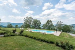 a swimming pool in the middle of a grass field at Il Serrino Family tra le montagne in Pistoia