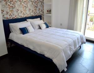 a large bed with white sheets and pillows in a bedroom at Kairos Suite in Modugno