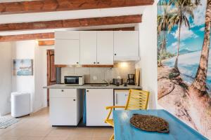 una cucina con mobili bianchi e tavolo di Casa caribe en finca santa Ana a Torre-Pacheco